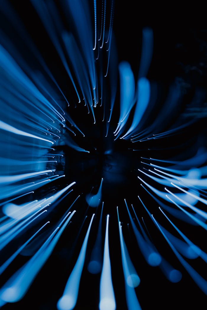 Dynamic abstract image showcasing blue light streaks captured in motion with a dark background.